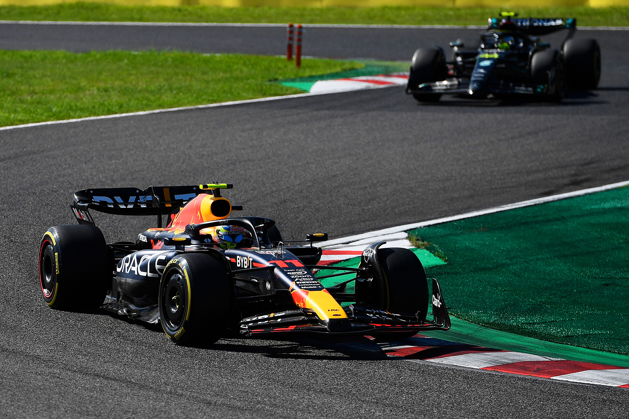 Sergio Pérez au volant de sa Red Bull RB19 lors du Grand Prix du Japon de Formule 1 2023, il devance Lewis Hamilton dans sa Mercedes W14 dans la dernière chicane du circuit de Suzuka.