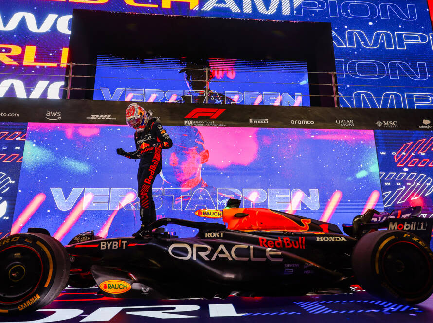 Le champion du monde de Formule 1 Max Verstappen célèbre sa victoire sur le museau de sa Red Bull RB19, devant des écrans géants célébrant son titre de champion du monde