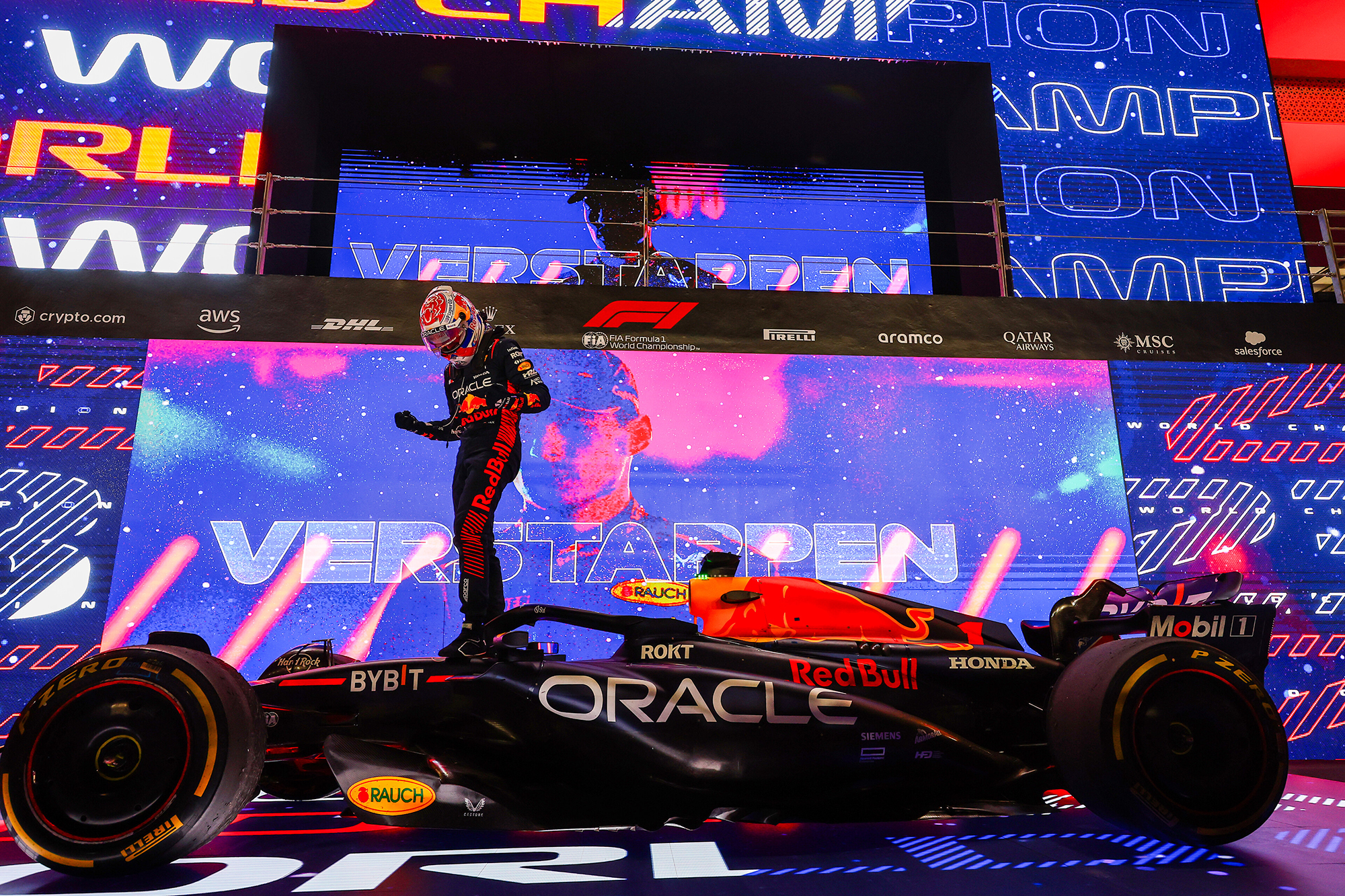 Le champion du monde de Formule 1 Max Verstappen célèbre sa victoire sur le museau de sa Red Bull RB19, devant des écrans géants célébrant son titre de champion du monde